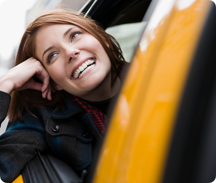 smiling woman leaning out of car window